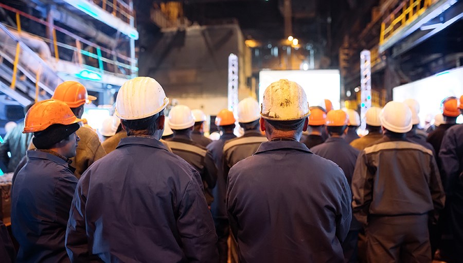 trabajadores en una fábrica con casco de seguridad